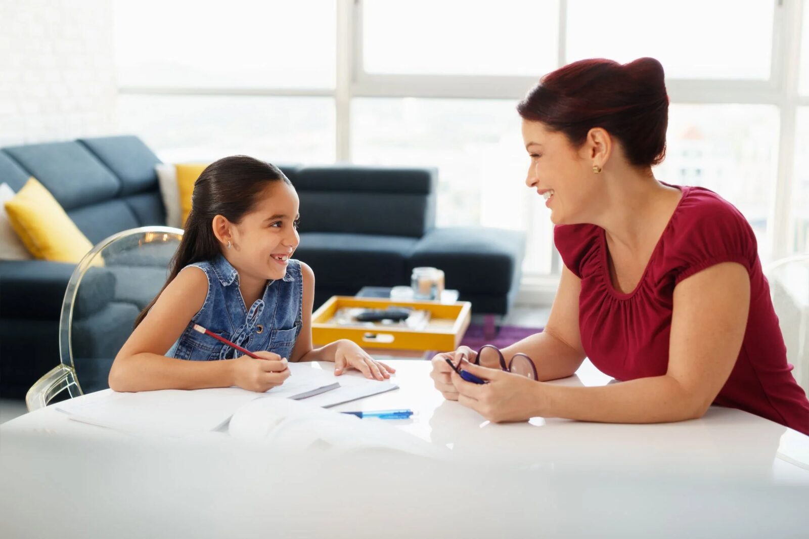 A school psychologist meeting with a young student across a table during an evaluation